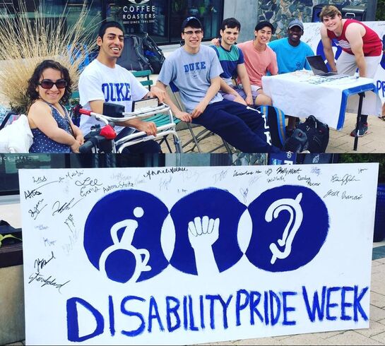 Image of students of mixed skin colors and visible and not visible disabilities, including a wheelchair user, a person who seems to have spina bifida, and a person who looks like someone with CP.  They're outside behind a poster signed with student names that says 