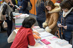 Picture of students at an information fair, looking at a booth